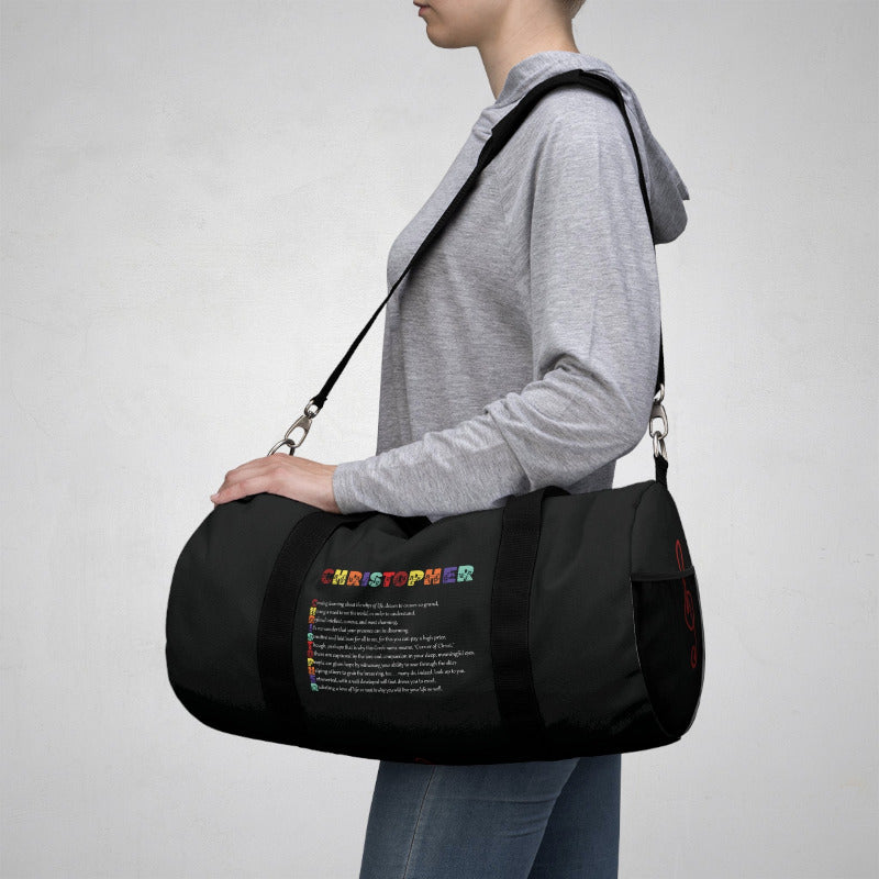 Person carrying a black duffel bag with colorful text on a gray background