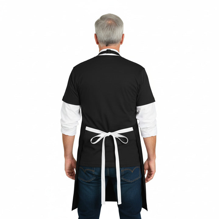 Person wearing a black apron with a white apron over it on a white background