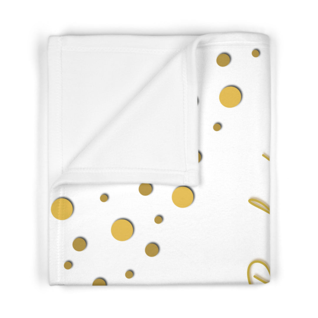 Oh, Baby acrostic poem folded blanket with gold text and confetti dots on white background
