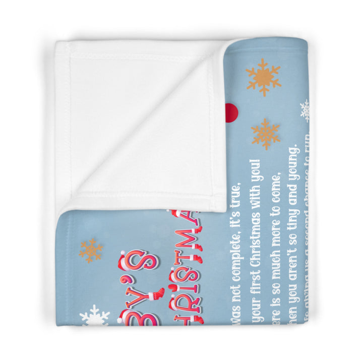 Baby blanket with Christmas text and snowflake designs on a white background