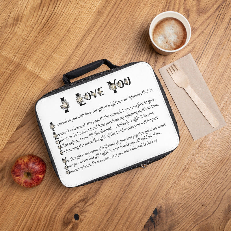 Lunch box with acrostic poem spelling out  'I Love You' message on a wooden table with an apple and coffee.