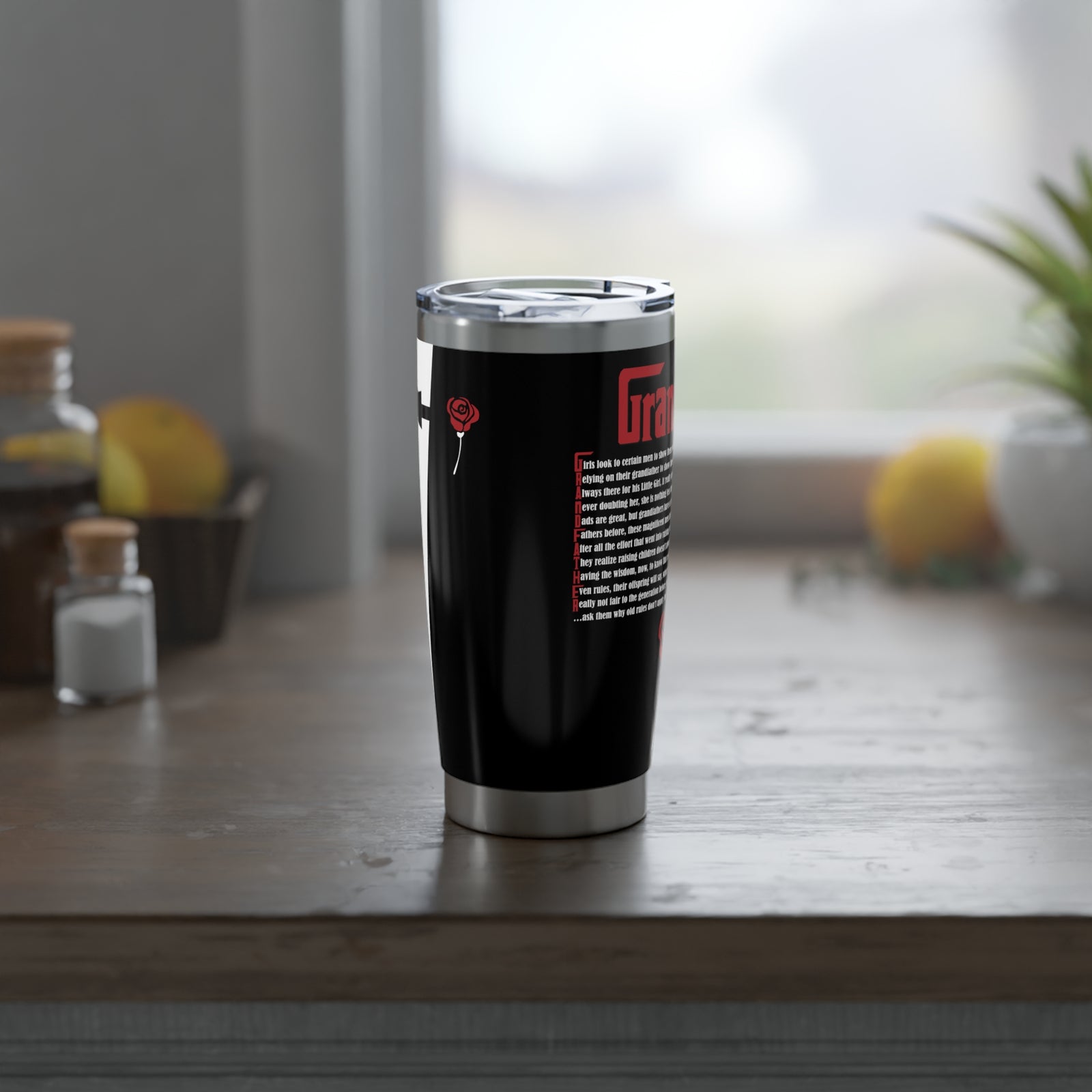 Black tumbler with a silver rim on a wooden surface with a blurred background
