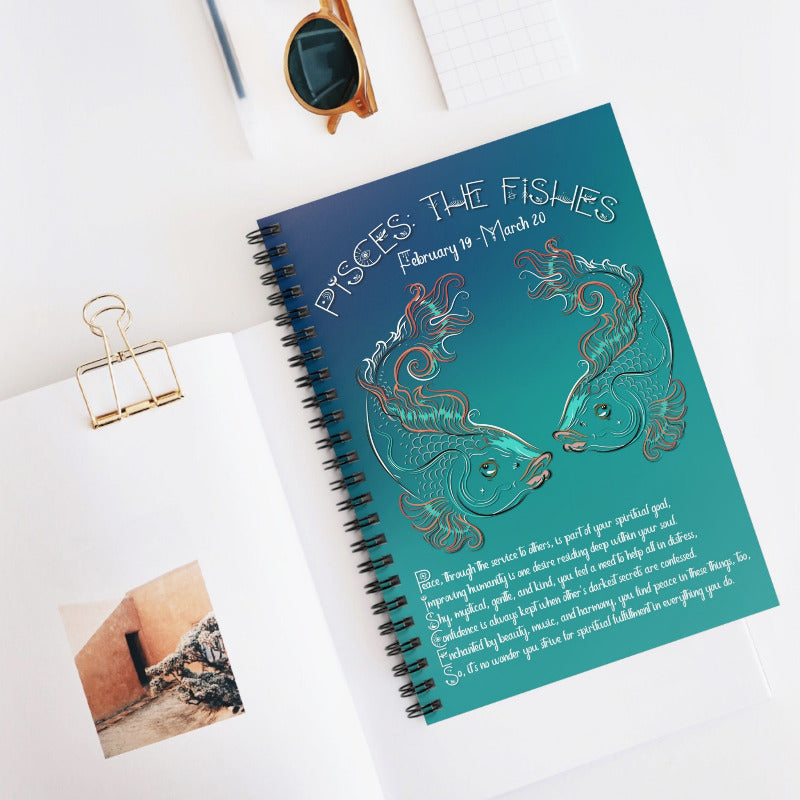 Spiral-bound notebook with Pisces zodiac design on a white surface