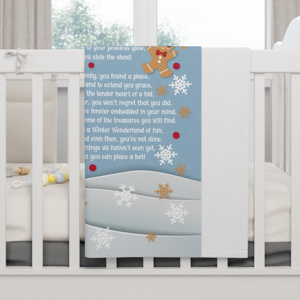 Baby crib with a decorative panel featuring gingerbread men and snowflakes on a blue background.