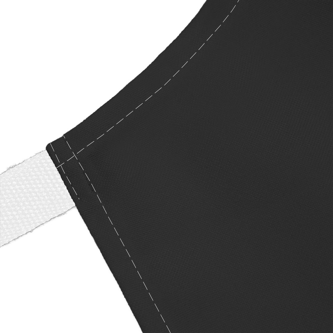 Close-up of a black apron with white strap on a white background