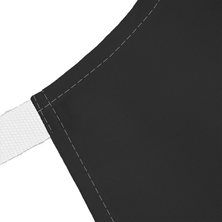 Close-up of a black apron with white strap on a white background