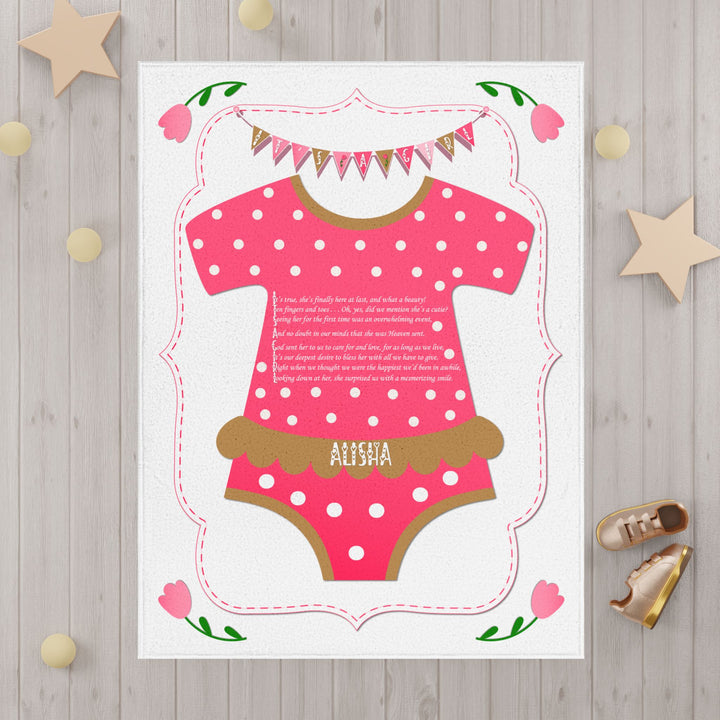 It's a Girl acrostic poem pink blanket with polka dot baby bodysuit design and decorative bunting on white wooden background
