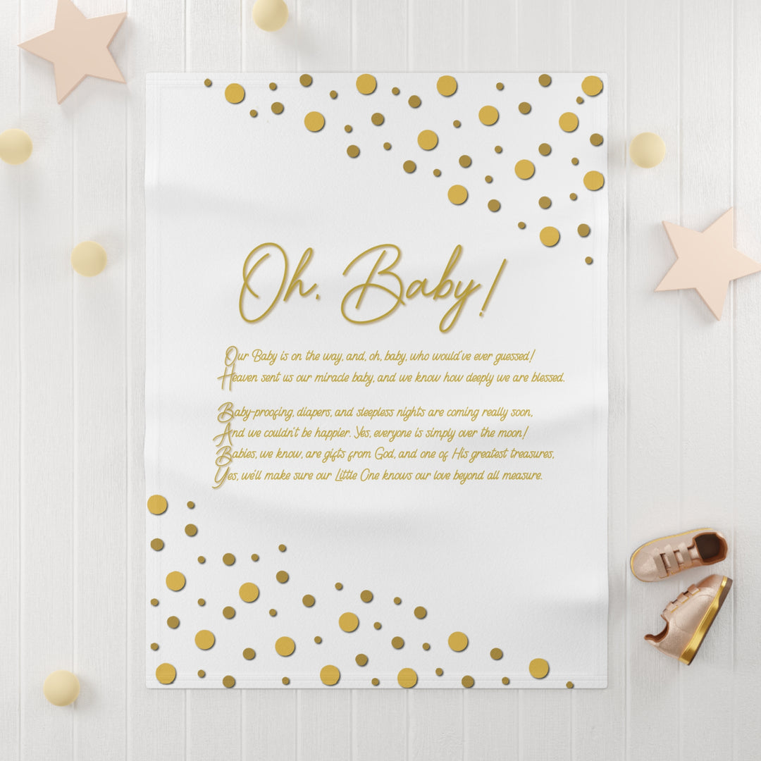 Oh, Baby acrostic poem blanket with gold text and confetti dots on white background with light wooden surface