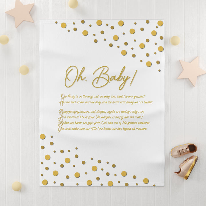 Oh, Baby acrostic poem blanket with gold text and confetti dots on white background with light wooden surface