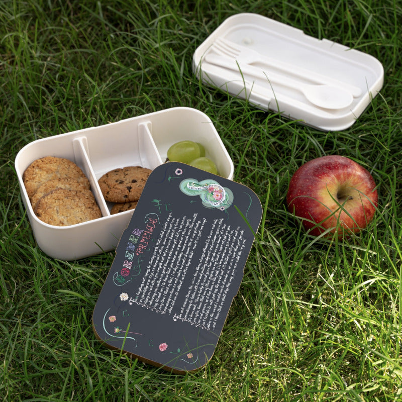 White bento box with compartments containing cookies and grapes, an apple, and a branded card on grass, and an acrostic poem spelling out Forever Friends.