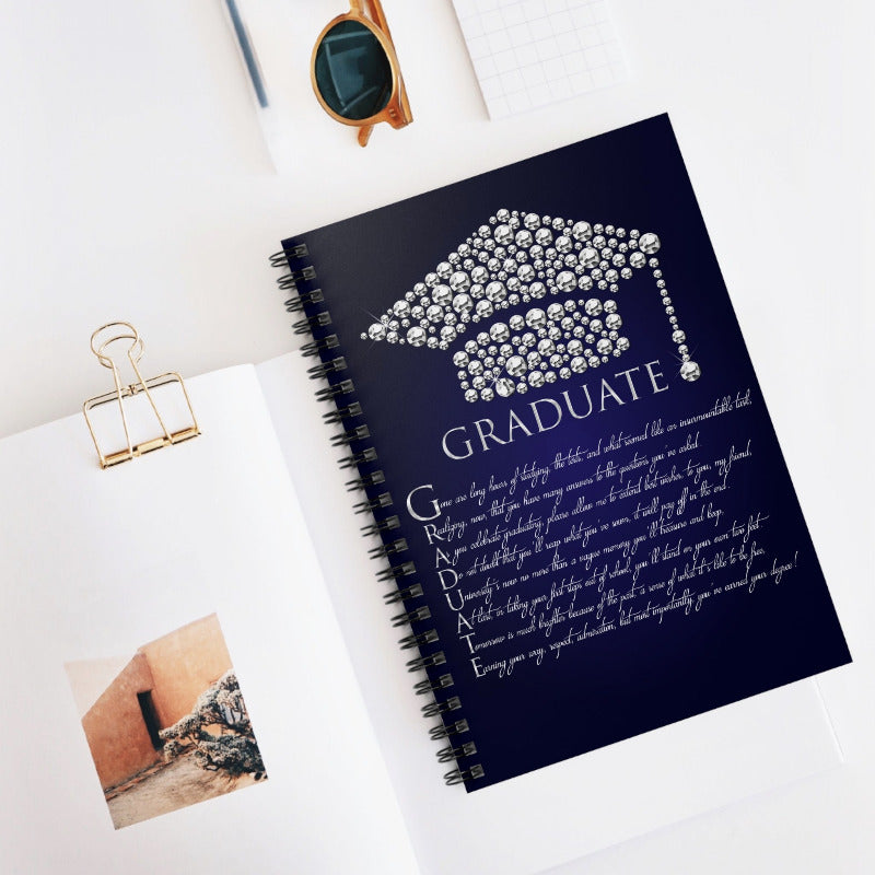 Navy blue notebook with a graduation cap design and 'GRADUATE' text on a white surface.