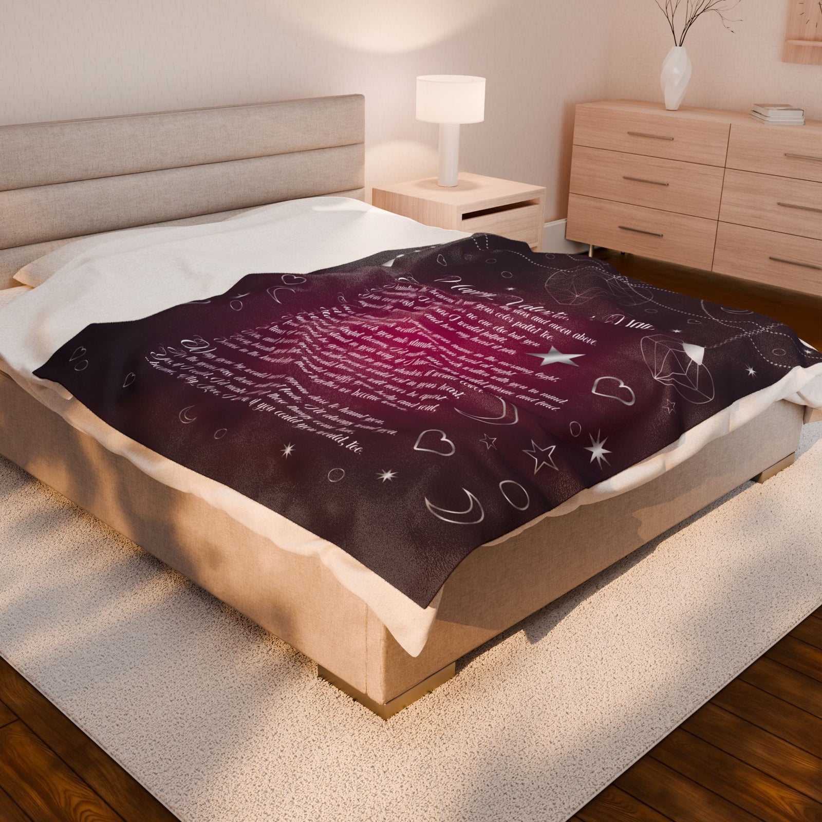 Bed with a dark purple blanket featuring white text and designs in a bedroom setting.
